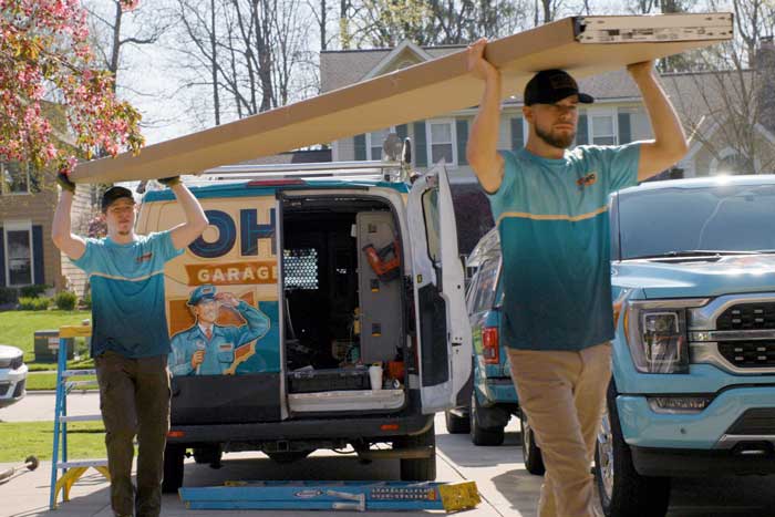 Ohio Garage Door Repair service technicians carrying a brand new garage door into a customers' garage