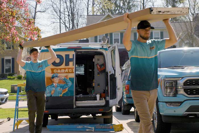 Ohio Garage Door Repair technicians carrying panels for a new garage door installation in Akron, Ohio