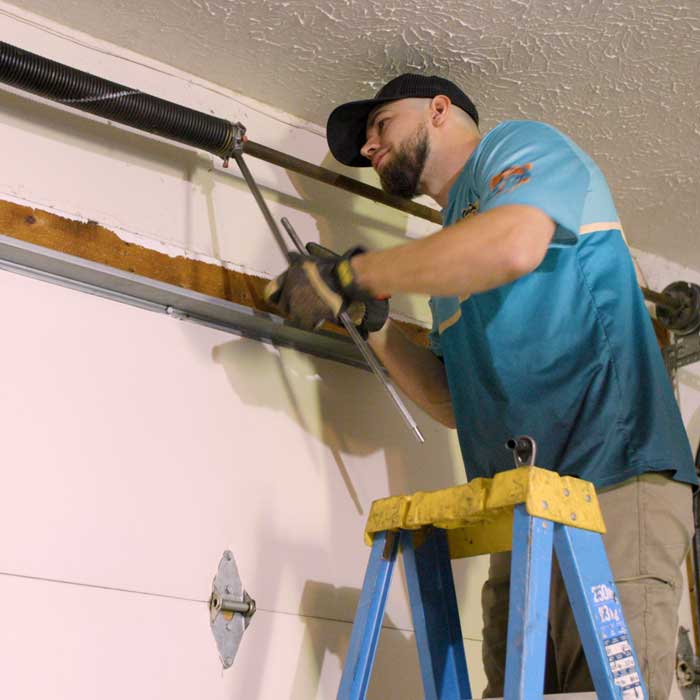 Garage Door Installation Brooklyn, OH An Ohio Garage Door Repair technician is using sidewinder tool while installing a new garage door spring near Brooklyn, OH