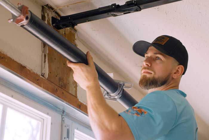 A local Ohio Garage Door Repair technician fixing a broken garage door spring near Streetsboro, Ohio